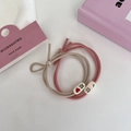 Detail view of two high-elastic pink and beige hair ties with cute lettered oval beads - Pink Series - Peach Delight
