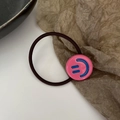 Élastique à cheveux noir avec un charm rond rose orné d'un motif visage souriant bleu - Rose