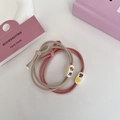 Close-up of pink and khaki hair ties with bow detail and cute patterned beads - Pink Series - No Worries