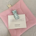 Pale green wavy metal hair clip with a pleated texture on a white decorative display card - Square Style / Holographic Blue