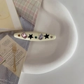 Y2K Haarspange aus cremegelbem Acryl mit bunten Strasssteinen und schwarzen Sternen - Cremeweiß