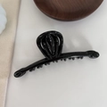 Close-up of a large glossy black hair claw clip for French-style hair styling - Black
