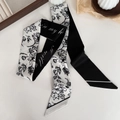 Detail of a black and white floral silk twilly scarf styled on a minimal white surface - 7# Black and White Floral