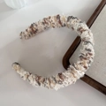 Detail of cream and gray knitted headband featuring soft sherpa bean texture on wood tray - White Coffee