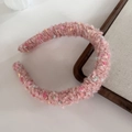 Detail of pink knitted headband featuring colorful yarn dots and soft textured fabric - Pink