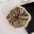 Detail of coffee twill fabric scrunchie with cream lace trim and minimalist label - Khaki