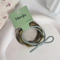 Detail of high-elasticity hair bands in grey, olive, and blue on a ceramic plate - Green