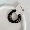 Detailed close-up of 6 durable black elastic hair bands with golden beads on card - Black
