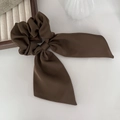 Elegant dark coffee satin silk bow scrunchie with long ribbons on a wooden tray - Brown