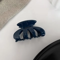 Detail of dark blue resin hair claw with golden Barrette La France lettering and glossy finish - Navy Blue