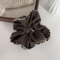 Detalle de coletero marrón café con tejido texturizado y ribete de flecos elegante - Gris Premium