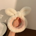 Dettaglio della morbida texture in peluche della fascia con orecchie di coniglio bianco e rosa - Bianco