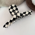 Macro shot of checkered acetic acid hair claw with golden Barrette La France engraving - Checkered