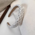 Close-up of a white tweed headband featuring black stitching and subtle silver glitter - White