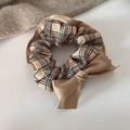 Detail of warm brown plaid scrunchie with satin bow on a cozy aesthetic background - Plaid Pattern
