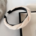 Détail du bandeau en maille torsadée crème avec une texture douce et des embouts noirs - Blanc Cassé