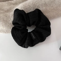 Close-up of black knit scrunchie with soft ribbed texture and Made in Korea label - Black