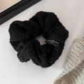 Detail van zwarte tweed scrunchie met gouden glitters en Blind For Love geweven label - Scrunchie / Zwart