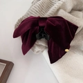 Detailed macro view of a burgundy velvet bow hair claw clip with golden metal charm - Burgundy