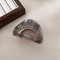 Detalle de pinza para pelo en acetato jaspeado con bisagra de metal dorado pulido - Gris