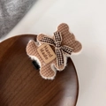 Detailed view of handmade brown knitted bear hair clip with bow on a wooden tray - Brown Bear