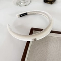 Detailed view of cream velvet padded headband with gold logo and handmade label - Off-white