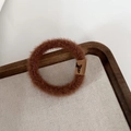 Close-up of soft plush brown hair tie with a butterfly tag on a wooden tray - Light Coffee
