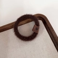 Close-up of soft plush coffee brown hair scrunchie with detailed leather logo tag - Dark Coffee