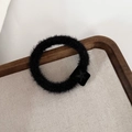 Gros plan sur un chouchou en peluche noire avec un charme carré à motif d'étoile - Noir