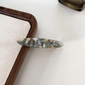 Détail de la pince à cheveux en acétate à motif marbré posée sur un plateau en bois - 5# Peinture à l'Huile Bleu Clair