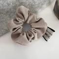 Detailansicht eines Scrunchies mit Fischgrätenmuster, Markenetikett und kaffeebrauner Textur - Hochelastisch (Beigegrau) / 1# Reisgrau