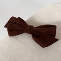 Detail shot of the dark brown velvet bow hair clip showing soft fabric texture - Brown