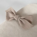 Detailed view of beige velvet bow hair clip on a soft textured fabric background - Beige Apricot
