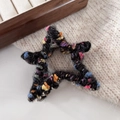 Detail of star-shaped hair claw clip with colorful crochet knit texture and silver spring - Black