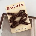 Detailed view of two leopard print plush bow hair clips displayed on a branded card - Dark Leopard Side Clip
