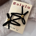 Pair of black velvet bow hair clips with golden heart accents on cozy knit background - BB Clips / Black