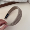 Détail du bandeau tricoté beige avec texture de fil épais et étiquette de marque noire - Serre-tête Café au Lait