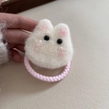 Nahaufnahme eines flauschigen Kaninchen-Haargummis mit Perlen und rosa Gummiband - Weiße Hasen Haargummi