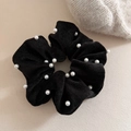 Elegante elastico in velluto nero con perline bianche su sfondo beige minimalista - Nero