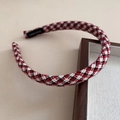 Detail eines rot-schwarzen Tweed-Haarreifens mit Karomuster und gewebtem Etikett-Design - Rot-Weiß-Karo Stil / Rot