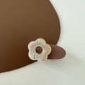 Detailed macro of a cute cream flower hair clip with marble texture on brown leather - Beige Flower
