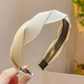 Detailed macro view of beige twisted fabric headband with internal anti-slip teeth - Beige