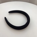 Macro shot of thick black sponge headband showing fine fabric texture and U-shaped curve - Black