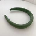 Close-up of thick dark green sponge headband with textured fabric and wide design - Green
