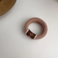 Dettaglio dell'elastico per capelli rosa cipria con etichetta in tessuto Smile marrone - Cachi