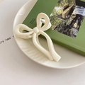 Dettaglio di una grande molletta a fiocco bianco crema per acconciature eleganti - Bianco