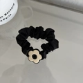 Primer plano de coletero de satén negro con colgante de flor crema en fondo blanco puro - Coletero / Negro