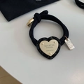 Vista macro dettagliata del ciondolo a cuore intrecciato su elastico nero in stile vintage - Stile Cuore