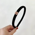 Close-up of black knitted headband featuring a brown leather patch with a rabbit icon - Black