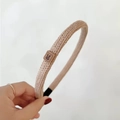 Close-up of beige knitted headband with a cute rabbit leather patch on a minimal background - Khaki